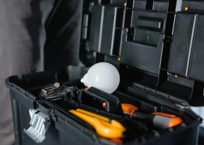 Open toolbox containing various tools and a light bulb.